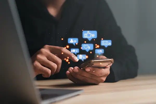 Man using a social media marketing concept on mobile phone with notification icons of like, message, comment and star above smartphone screen Man using a social media marketing concept on mobile phone with notification icons of like, message, comment and star above smartphone screen
